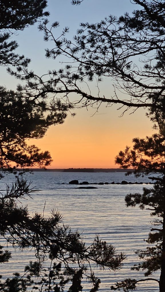 Hieno punainen ilta-aurinko meren rannalla.